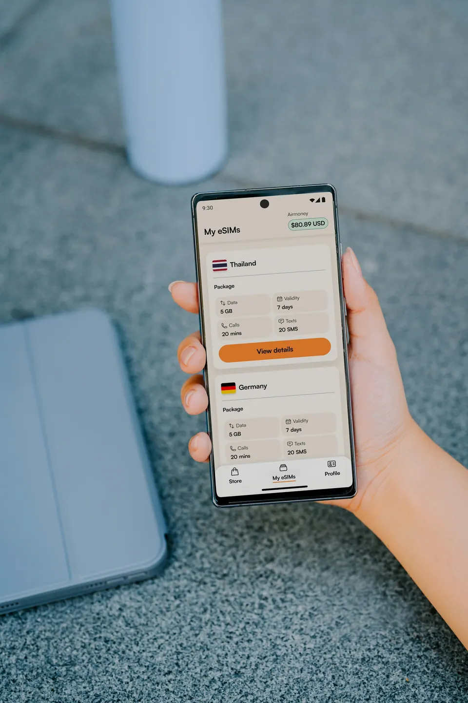 A hand holding an Android phone displaying Airalo’s My eSIMs list