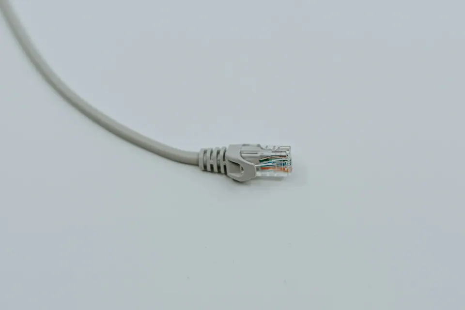 An Ethernet cable and connector on a pale surface