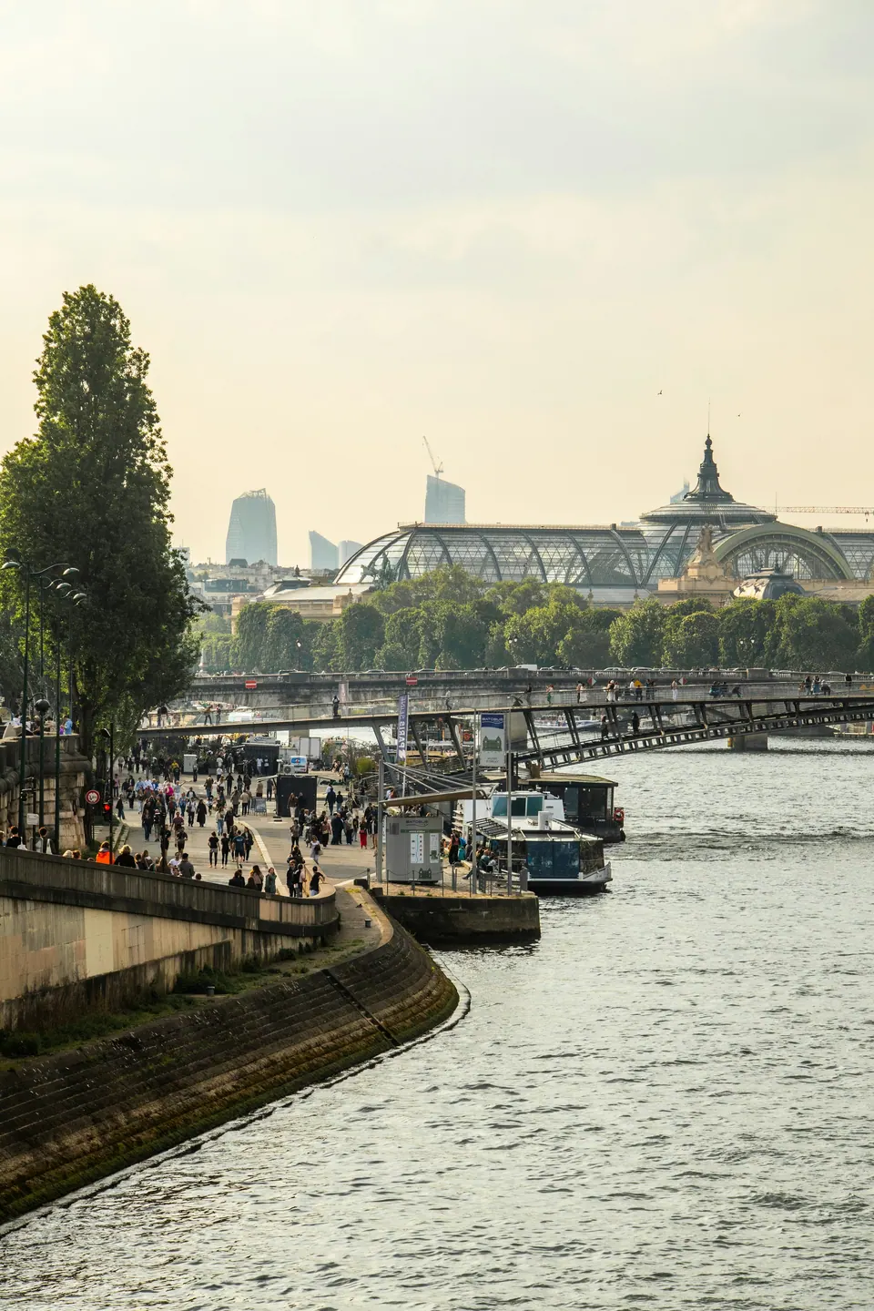 Walkways and boats along the Seine with the Grand Palais in Paris