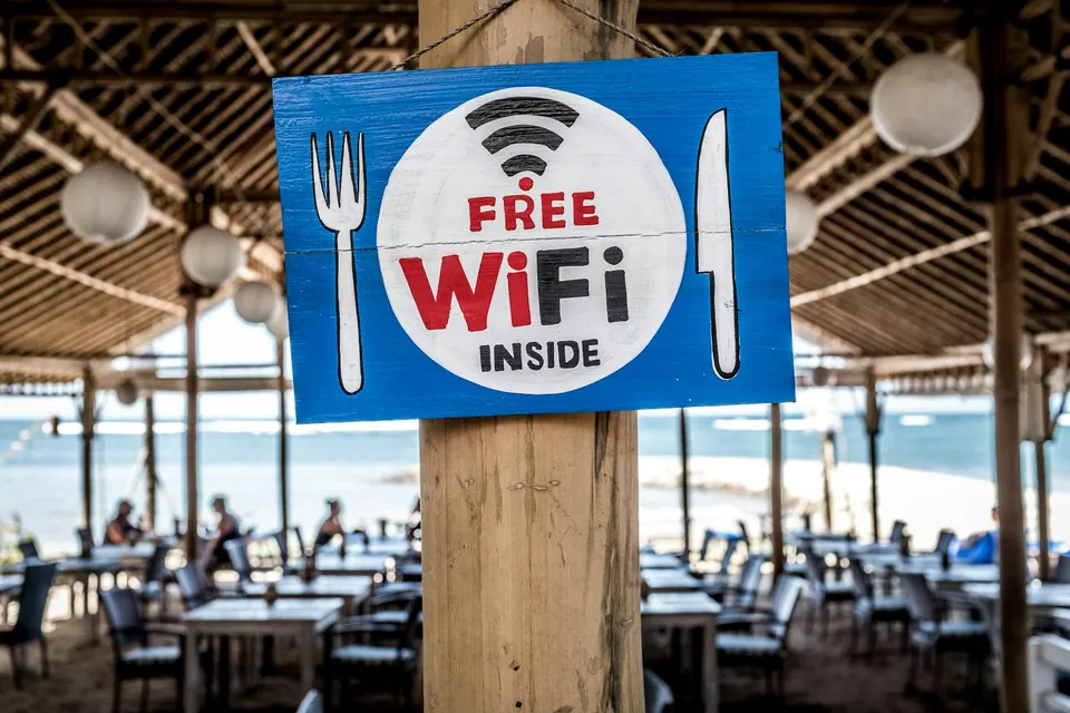 A Free WiFi sign on a wooden post at a beach café