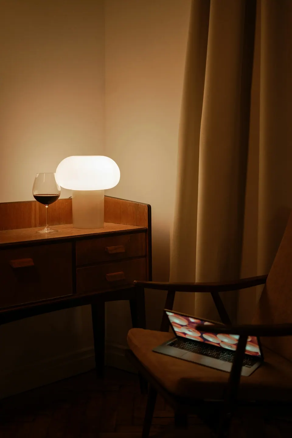 A desk and chair beside a lamp in a hotel room
