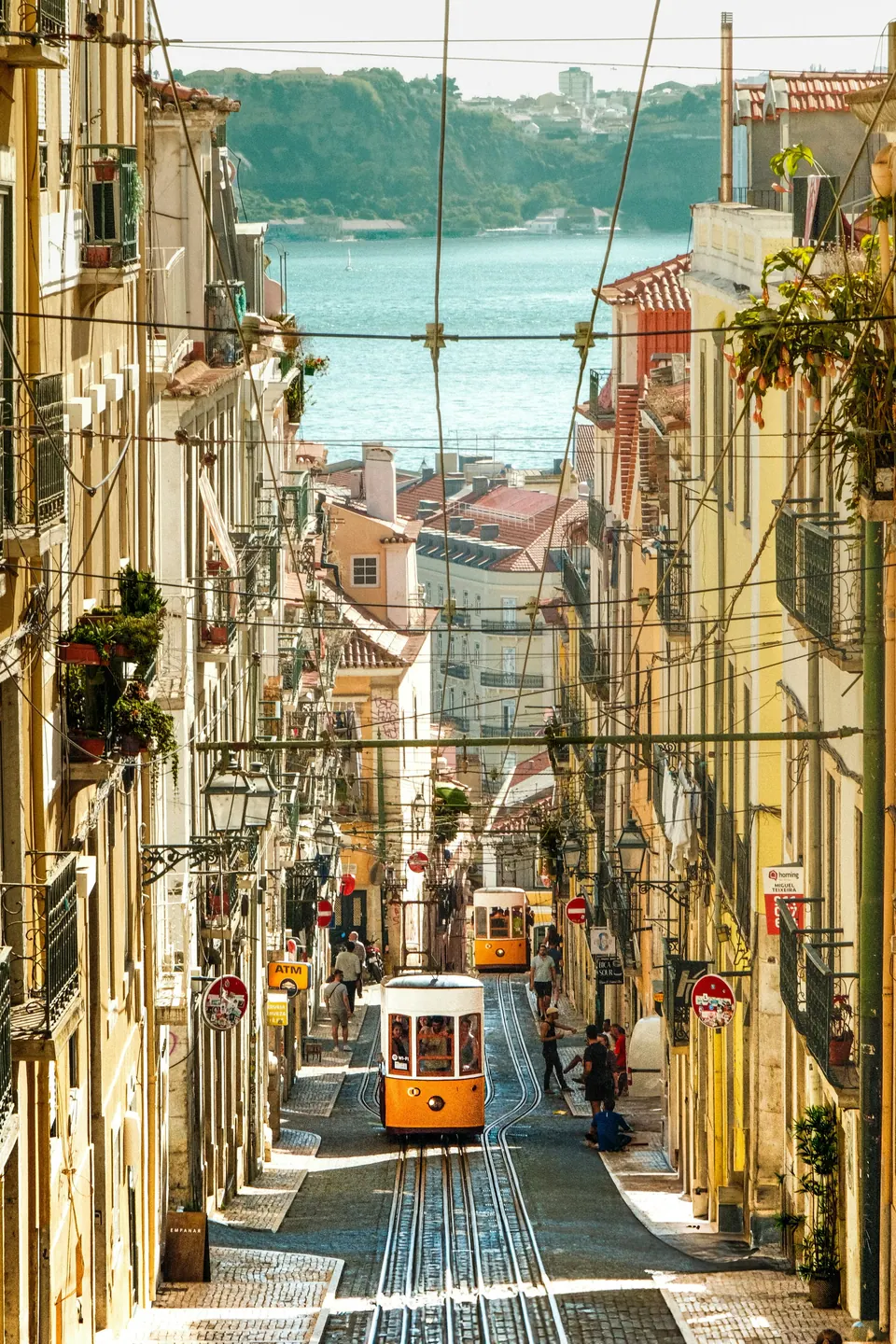 Trams on the steep tracks of Lisbon’s Elevador da Bica between colorful buildings