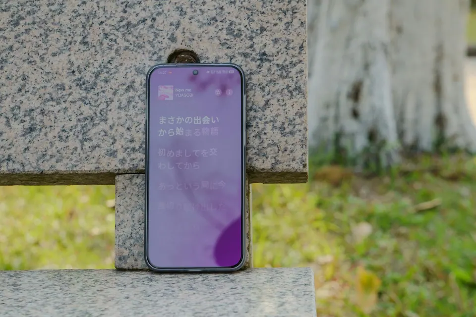 A phone resting unattended against the back of an outdoor bench