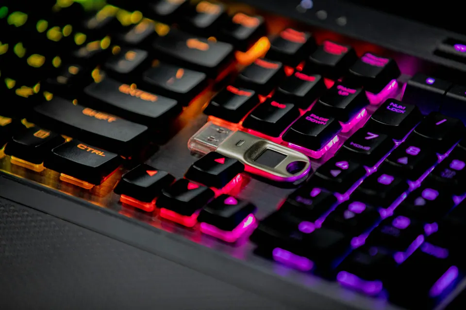 A USB security key resting on an illuminated computer keyboard